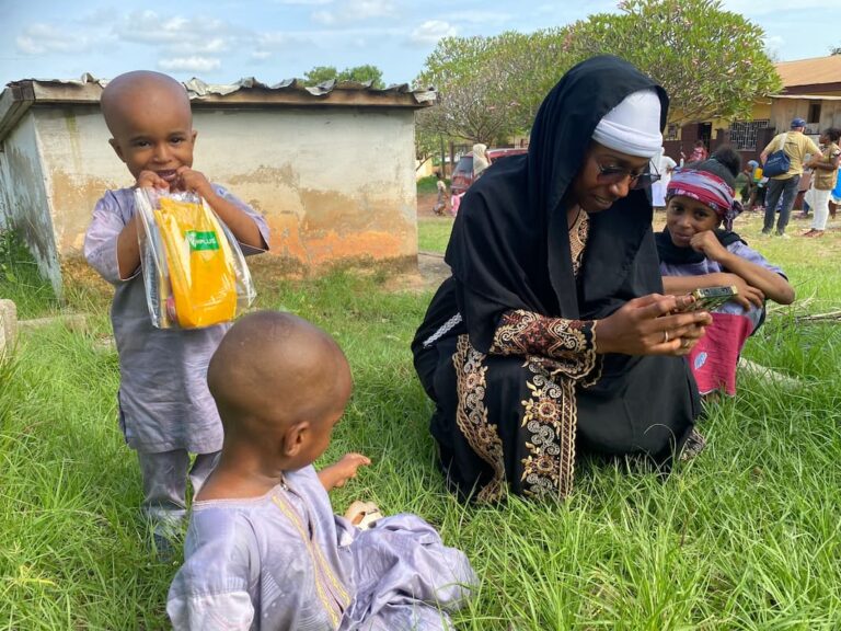 Beneficiaria del programa Nutri-m con sus hijos, consultando un sms con consejos nutricionales