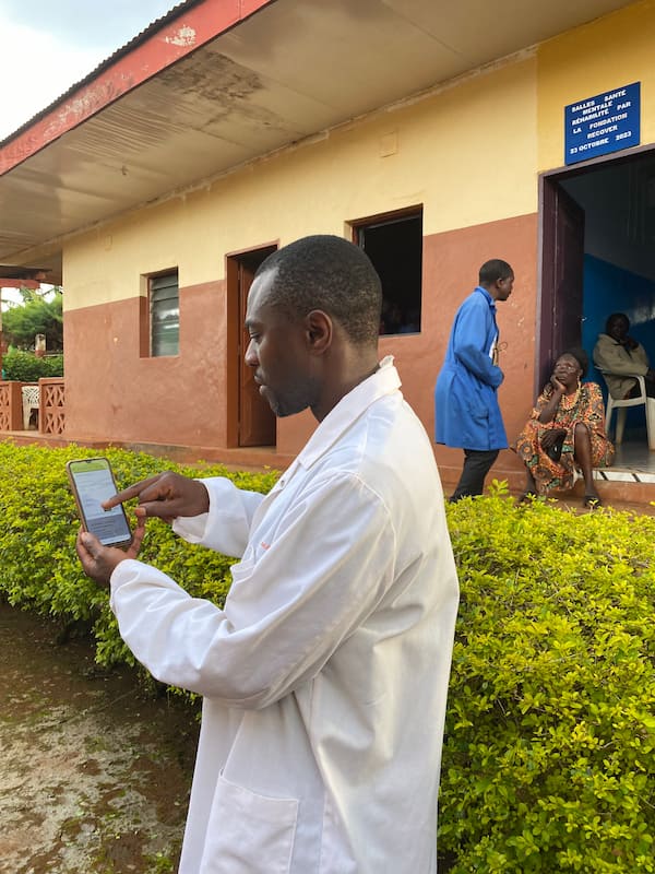 Técnico de salud mental mostrando el uso de la plataforma de Telemedicina en su móvil