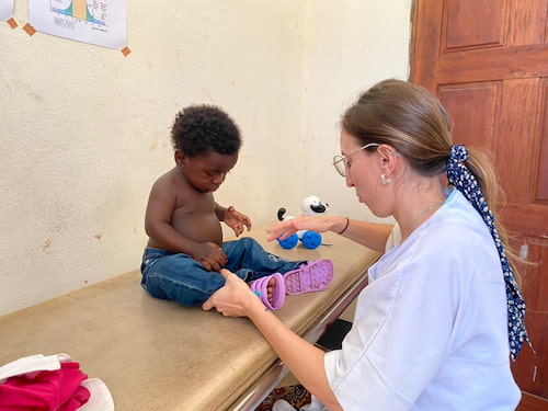 Una fisioterapeuta voluntaria atendiendo a un niño en Camerún